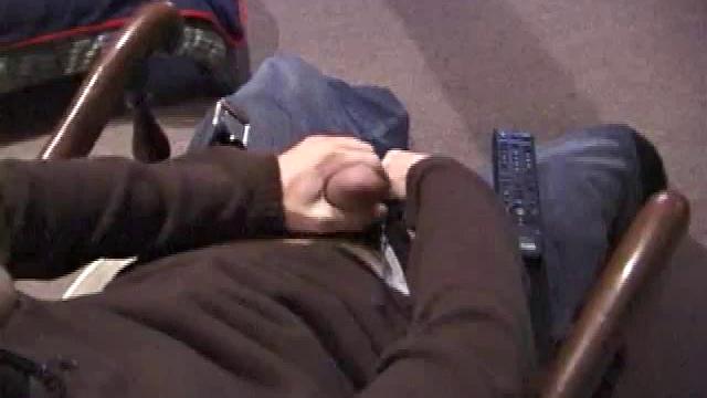 By the time the camera finds him, Dan is already going for his woody. He seems uncomfortable in the chair, so he stands up and moves to the staircase, where we can see his cock getting harder and harder.