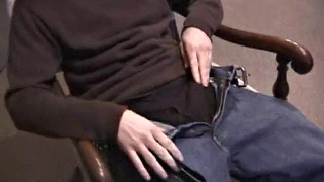 By the time the camera finds him, Dan is already going for his woody. He seems uncomfortable in the chair, so he stands up and moves to the staircase, where we can see his cock getting harder and harder.