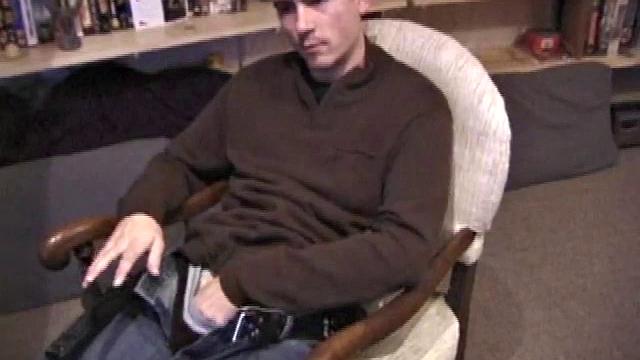 By the time the camera finds him, Dan is already going for his woody. He seems uncomfortable in the chair, so he stands up and moves to the staircase, where we can see his cock getting harder and harder.