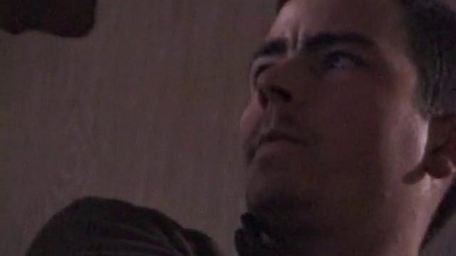 By the time the camera finds him, Dan is already going for his woody. He seems uncomfortable in the chair, so he stands up and moves to the staircase, where we can see his cock getting harder and harder.