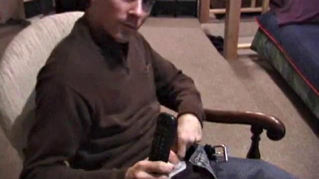 By the time the camera finds him, Dan is already going for his woody. He seems uncomfortable in the chair, so he stands up and moves to the staircase, where we can see his cock getting harder and harder.