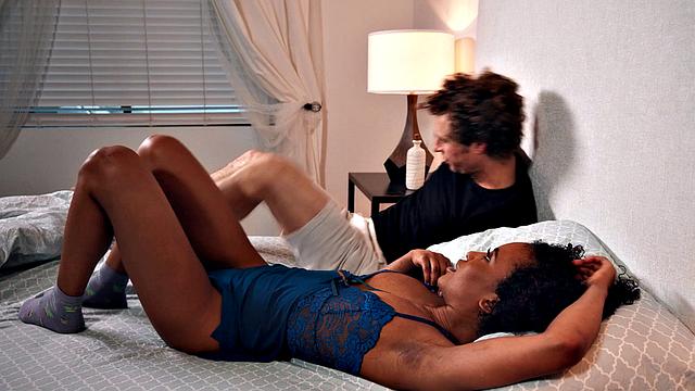 Curly-haired babe in red lingerie enjoys threesome action in bedroom