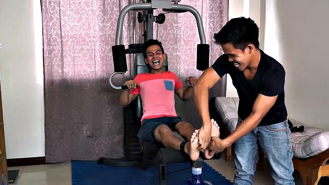 Jacob enjoys tickling male feet. And he's got cute Warren strapped down on the home gym for some foot tickling fun. Jacob keeps Warren laughing as he works his ribs and pits but then immediately returns to those smooth Asian boy feet.
