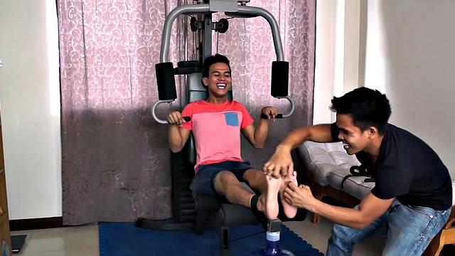 Jacob enjoys tickling male feet. And he's got cute Warren strapped down on the home gym for some foot tickling fun. Jacob keeps Warren laughing as he works his ribs and pits but then immediately returns to those smooth Asian boy feet.