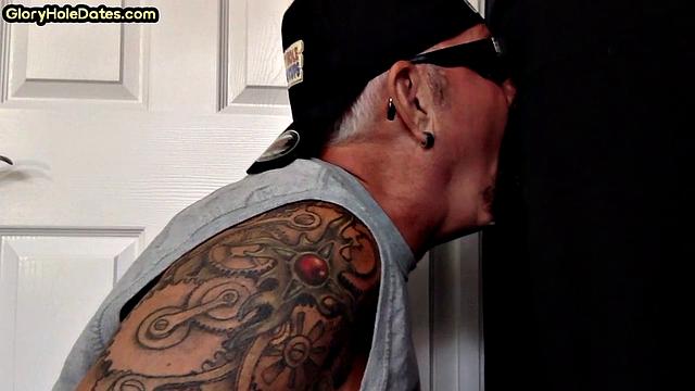 Gaydaddy with tattoos sucks hard cock in gloryhole