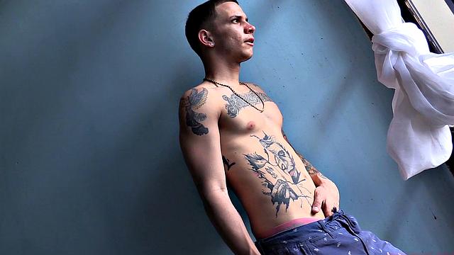 Standing in the natural light of a glass door, Olaf strips naked, working up a big boner. Once naked, he sits on the edge of a bed and starts beating off in earnest.