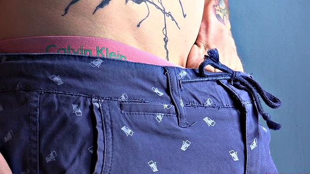 Standing in the natural light of a glass door, Olaf strips naked, working up a big boner. Once naked, he sits on the edge of a bed and starts beating off in earnest.