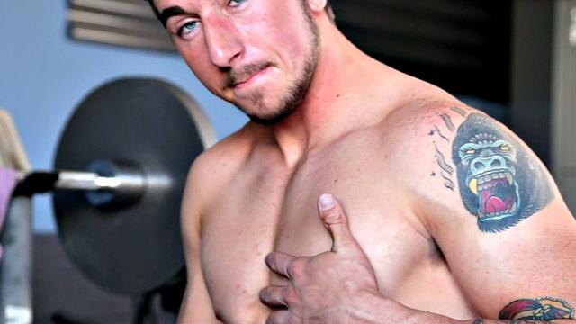 Tattooed stud masturbating in the gym