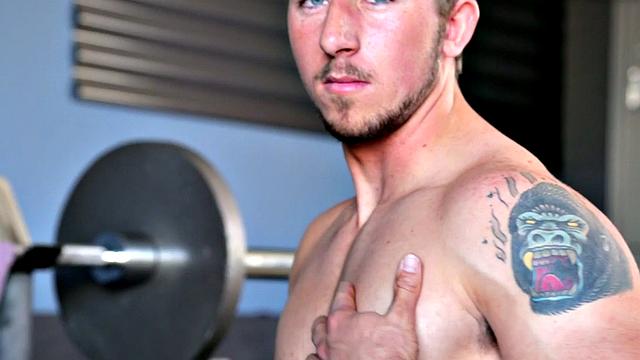 Tattooed stud masturbating in the gym