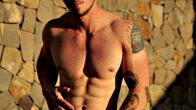 Tattooed stud masturbating in the gym