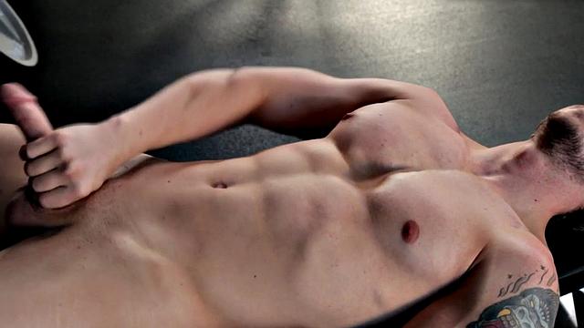 Tattooed stud masturbating in the gym