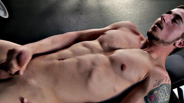 Tattooed stud masturbating in the gym