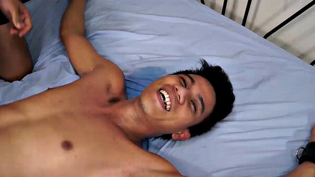 Jacob has his sexy buddy Simon spreadeagled on the bed for some tickling fetish action. Jacob loves tickling so he spends plenty of time on those Asian boy feet. But that's not to say Simon isn't ticklish on his upper body.