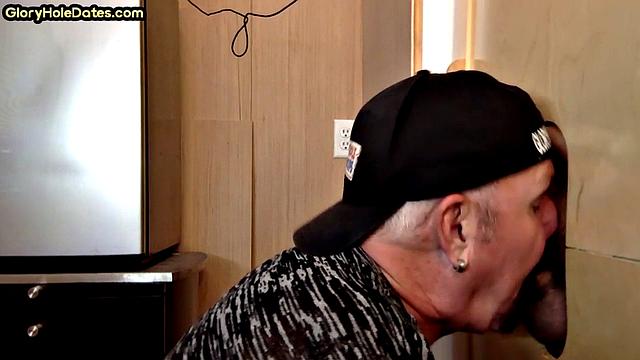 Папик сосёт член в глори-холе и доводит до кончи руками