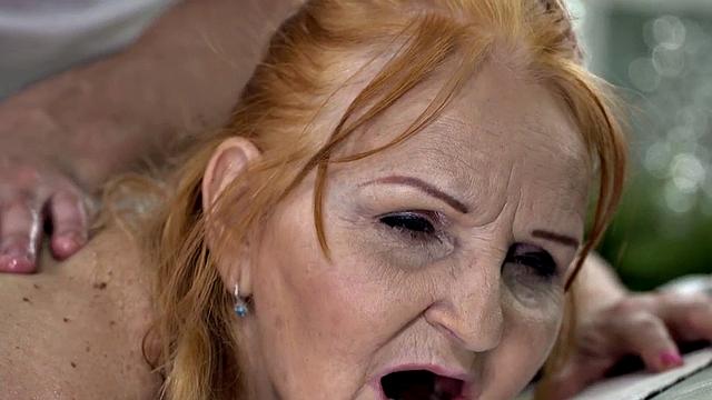 Old granny pleased by masseur on massage table