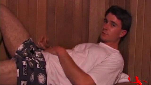 Adam relaxes on the floor watching porn video, strokes cock, plays with butthole, and blasts cum load onto skateboard