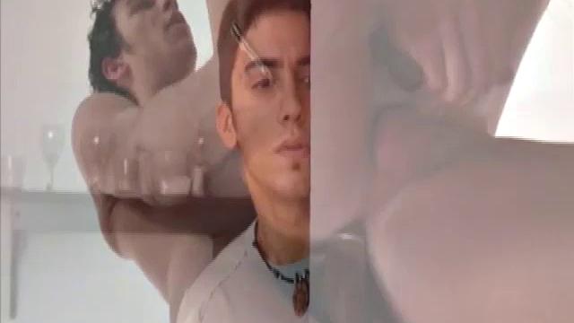 Niko Tomiar and Oscar Blanco are relaxing on the couch. Niko is with curly black hair and big white smile. Oscar knows it, too. He starts rubbing all over Niko as the two kiss.