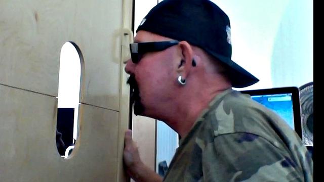 thick black cock teases hungry mouths at the gay gloryhole