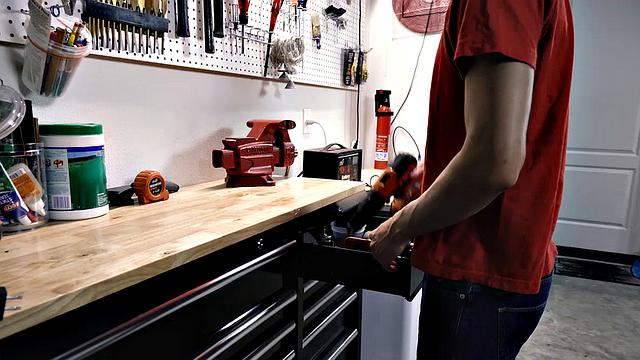 Dad gets rough with his grown son on the workbench-guess that's one way to bond