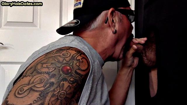татуированный зрелый мужик сосёт в глори-холе и глотает сперму