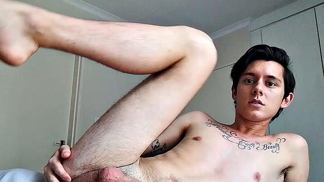 Ant is a slim and smooth twink, with that boy next door look, until the shirt peels off revealing an inked chest. He pushes his shorts down just enough to give us a peek at his fine looking little butt and big uncut cock.