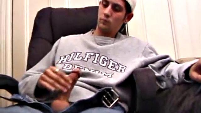 As a porn flick plays, young amateur Aaron Michaels strokes hard, pulls his cock out of his jeans, lets loose, and spills his nut on the bed.