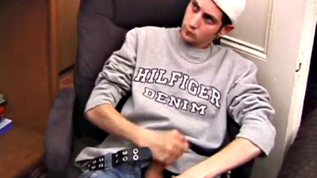 As a porn flick plays, young amateur Aaron Michaels strokes hard, pulls his cock out of his jeans, lets loose, and spills his nut on the bed.