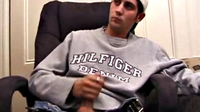 As a porn flick plays, young amateur Aaron Michaels strokes hard, pulls his cock out of his jeans, lets loose, and spills his nut on the bed.