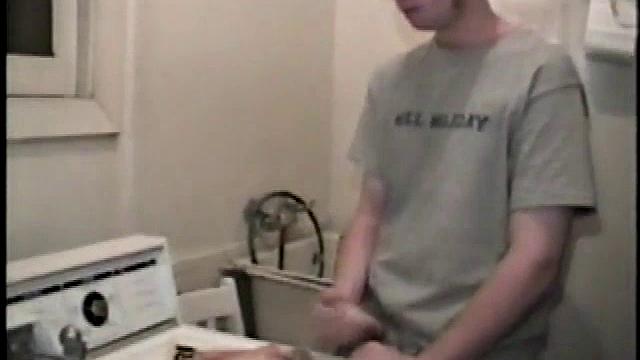 Boy-next-door spreads his new straight porn magazine on top of the washing machine and pulls his cock out of the fly.