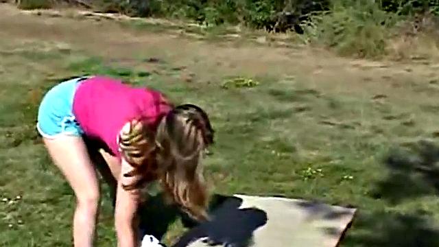 Little April fingers her wet pussy in shorts outdoors