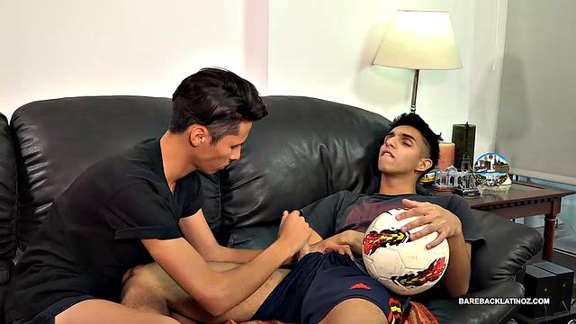 Back from a game of soccer, young Latinos Fabrice and Dimitri relax on the sofa and flirt with each other.