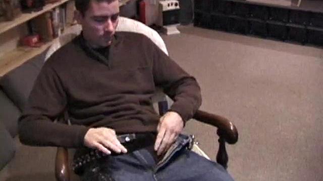 By the time the camera finds him, Dan is already going for his woody. He seems uncomfortable in the chair, so he stands up and moves to the staircase, where we can see his cock getting harder and harder.