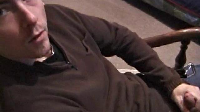 By the time the camera finds him, Dan is already going for his woody. He seems uncomfortable in the chair, so he stands up and moves to the staircase, where we can see his cock getting harder and harder.