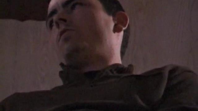 By the time the camera finds him, Dan is already going for his woody. He seems uncomfortable in the chair, so he stands up and moves to the staircase, where we can see his cock getting harder and harder.