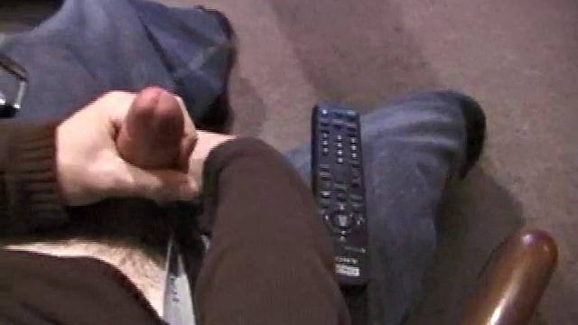 By the time the camera finds him, Dan is already going for his woody. He seems uncomfortable in the chair, so he stands up and moves to the staircase, where we can see his cock getting harder and harder.
