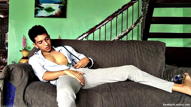 On a sofa, Santiago slowly strips down and pulls his big uncut cock out. The slim Latino never gets completely naked, as he beats off with determination.