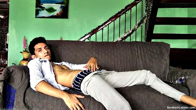On a sofa, Santiago slowly strips down and pulls his big uncut cock out. The slim Latino never gets completely naked, as he beats off with determination.