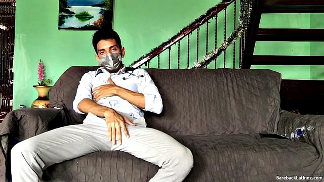 On a sofa, Santiago slowly strips down and pulls his big uncut cock out. The slim Latino never gets completely naked, as he beats off with determination.