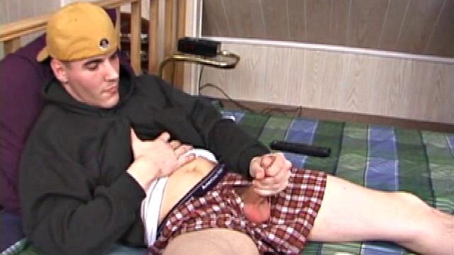 Relaxed on the bed, Timmy unzips his jeans and pulls out his cock. He strokes to the porn video he's watching. After edging himself a few times, the young man spills a messy cum load onto his stomach.