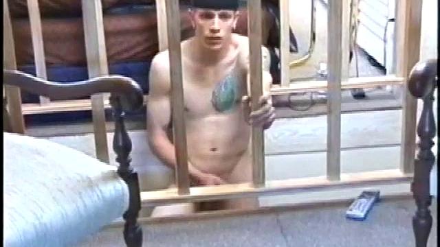 Dressed in baggy shorts and a baseball cap, Shane stands halfway up a short stairway, watching his porn video while talking about making the wall the target for his cum shot.