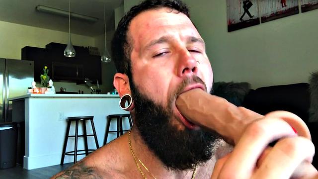 Bearded jock rides huge dildo while masturbating