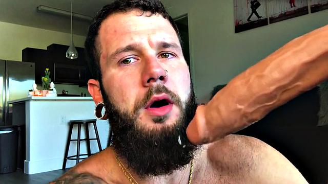 Bearded jock rides huge dildo while masturbating