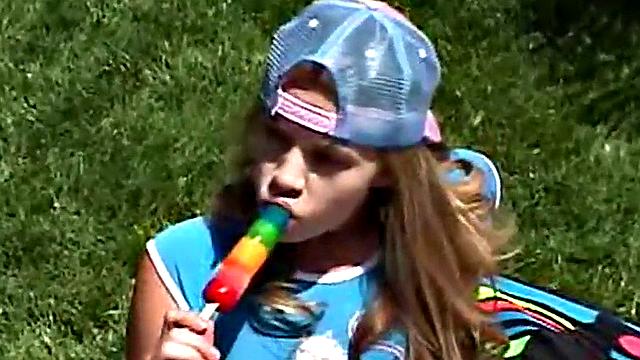 Little April sucking on a popsicle