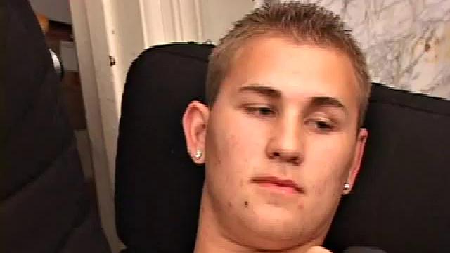 Adrian Knutts strips naked and works the remote control as he strokes his cock to the porn video.