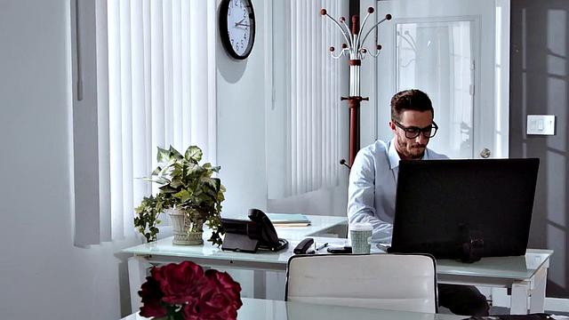 Man pounds busty babe in the office while she licks his shaft