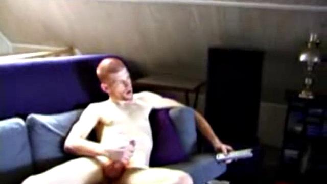 Shane and Tristian are talking about how horny the video is making them when they decide to relieve the pressure. Shane gets up and moves to the bed, while Tristian strokes his cock on the sofa.