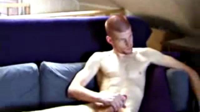 Shane and Tristian are talking about how horny the video is making them when they decide to relieve the pressure. Shane gets up and moves to the bed, while Tristian strokes his cock on the sofa.