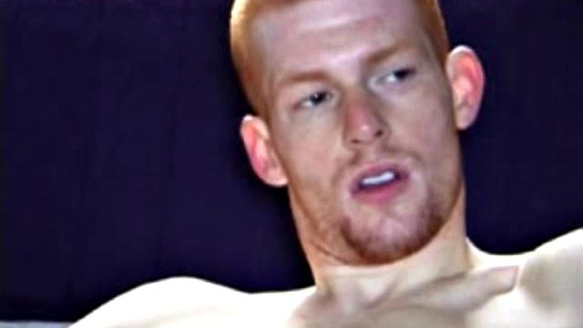 Shane and Tristian are talking about how horny the video is making them when they decide to relieve the pressure. Shane gets up and moves to the bed, while Tristian strokes his cock on the sofa.