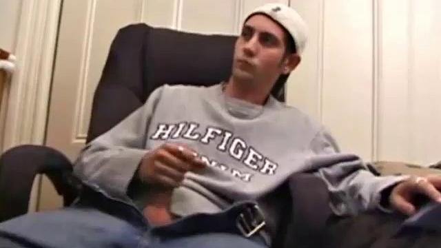 As a porno plays, Aaron strokes himself and pulls his cock out of his jeans. After a nice long stroke show, this man spills his warm sticky cum onto the bed.