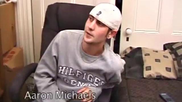 As a porno plays, Aaron strokes himself and pulls his cock out of his jeans. After a nice long stroke show, this man spills his warm sticky cum onto the bed.